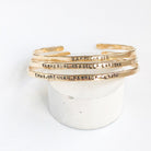 3 gold textured bangle bracelets with stamped personalization on the outside. Personalized Caroline Bangle by Sarah Cornwell Jewelry