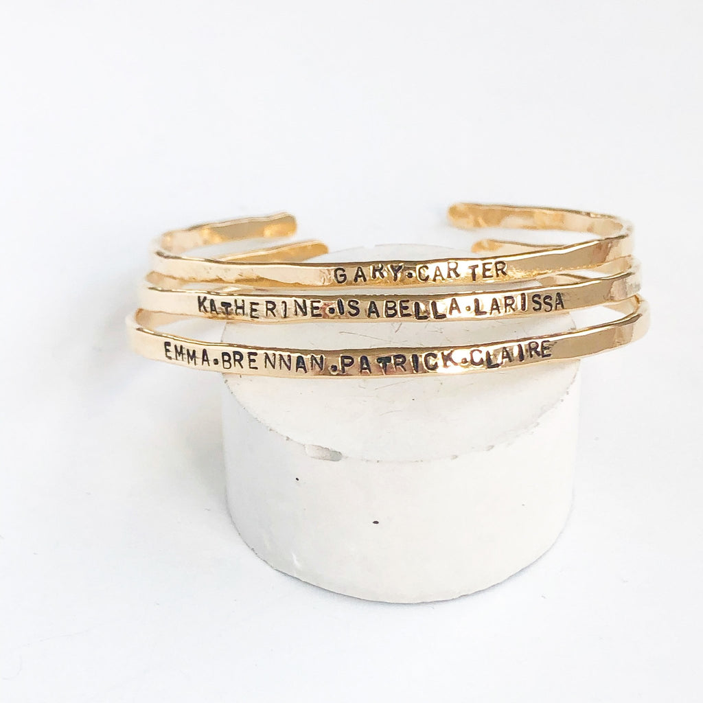 3 gold textured bangle bracelets with stamped personalization on the outside. Personalized Caroline Bangle by Sarah Cornwell Jewelry