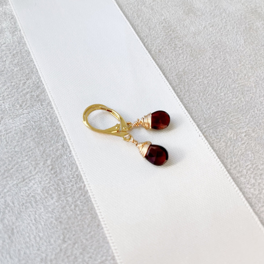 Gold wire wrapped garnet gemstone drop earrings with a lever back. Poppy Garnet Earrings by Sarah Cornwell Jewelry