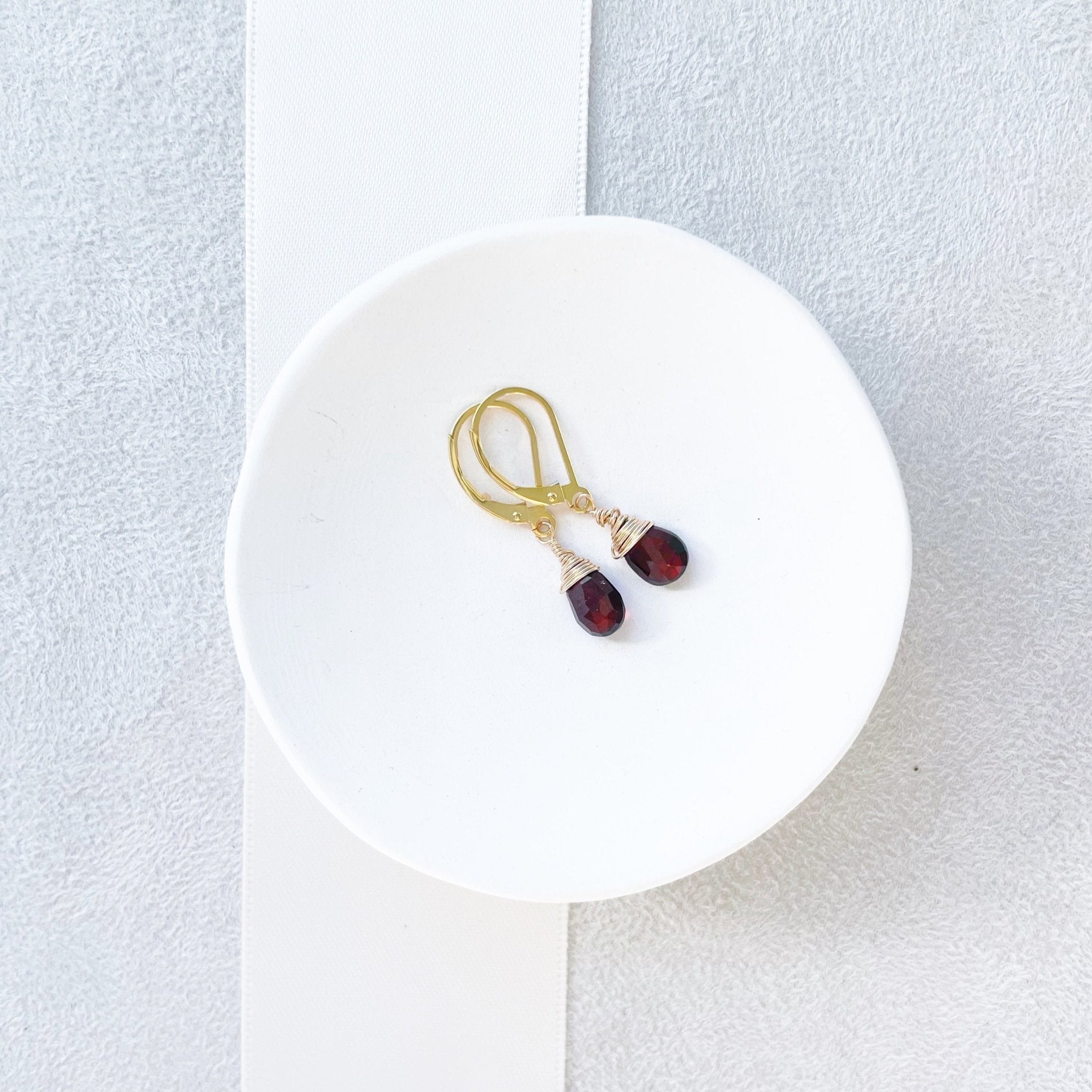 Gold wire wrapped garnet gemstone drop earrings with a lever back. Poppy Garnet Earrings by Sarah Cornwell Jewelry