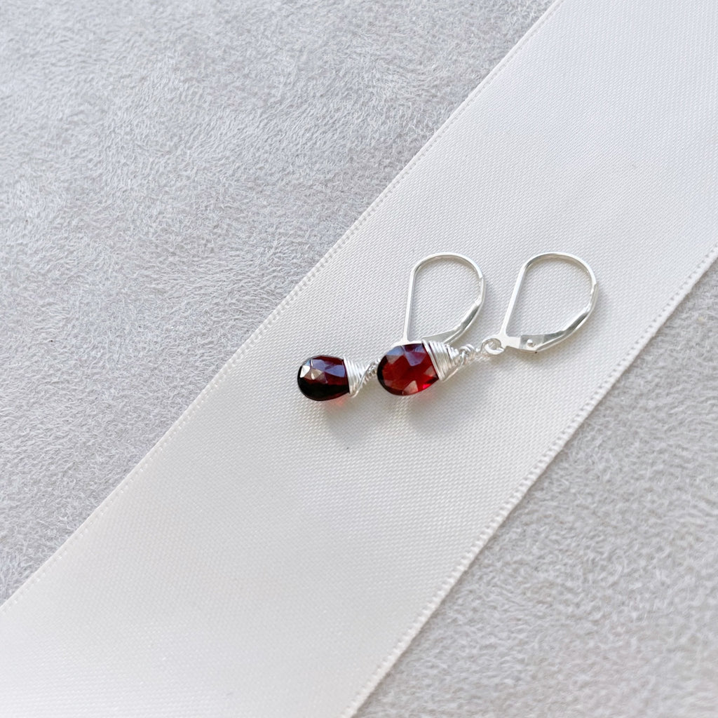 Silver wire wrapped garnet gemstone drop earrings with a lever back. Poppy Garnet Earrings by Sarah Cornwell Jewelry