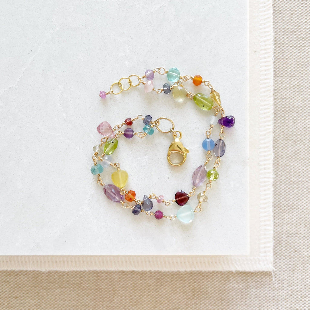 Gold and rainbow gemstone bracelet with wire wrapped aquamarine, peridot, quartz, amethyst, sapphires, chalcedony, citrine, smokey quartz, garnet, and labradorite gemstones. Poppy Love Bracelet by Sarah Cornwell Jewelry