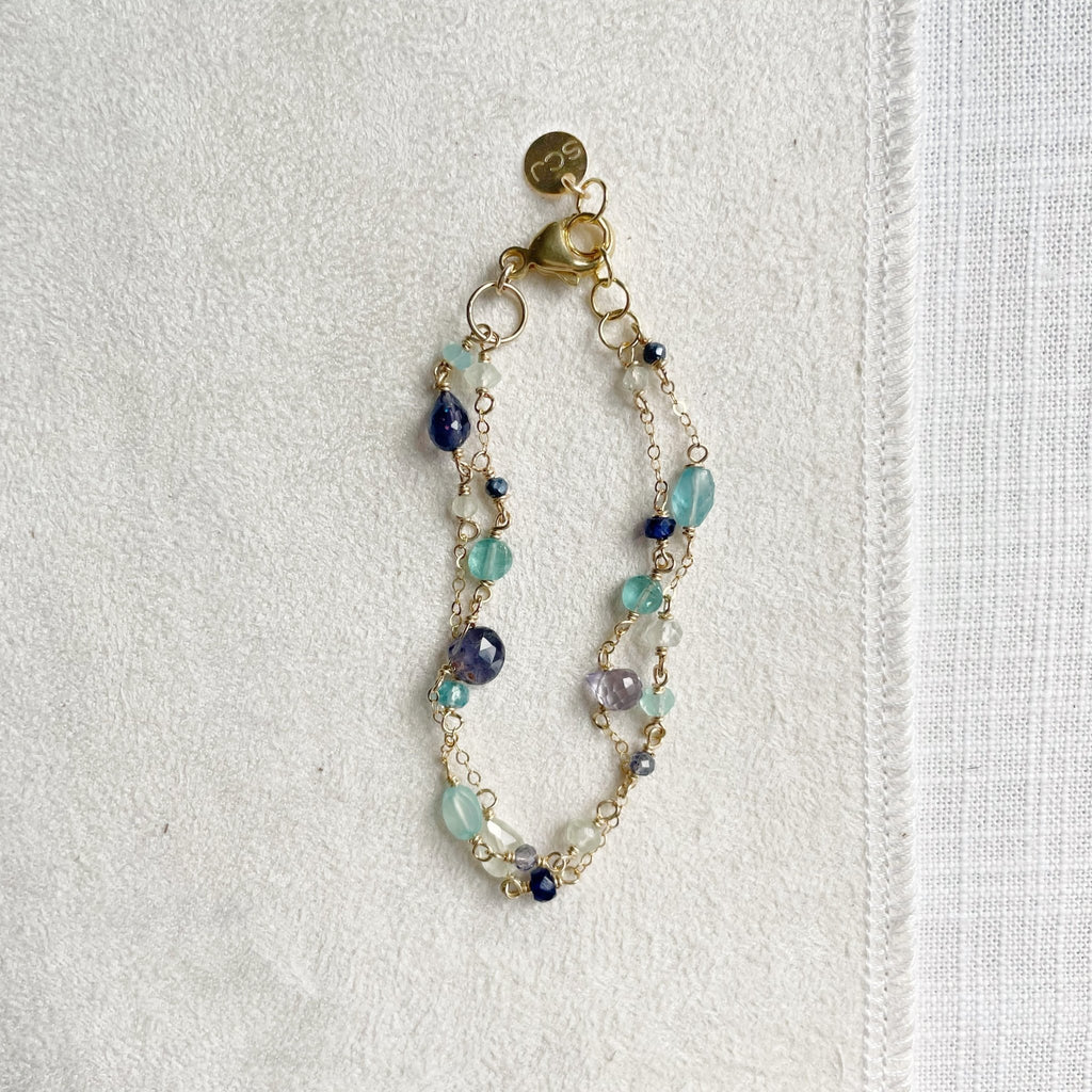 Gold double strand blue hued gemstone bracelet with hand wire wrapped prehnite, blue sapphire, chalcedony, and apatite gemstones. Poppy Seaside Bracelet bySarah Cornwell Jewelry