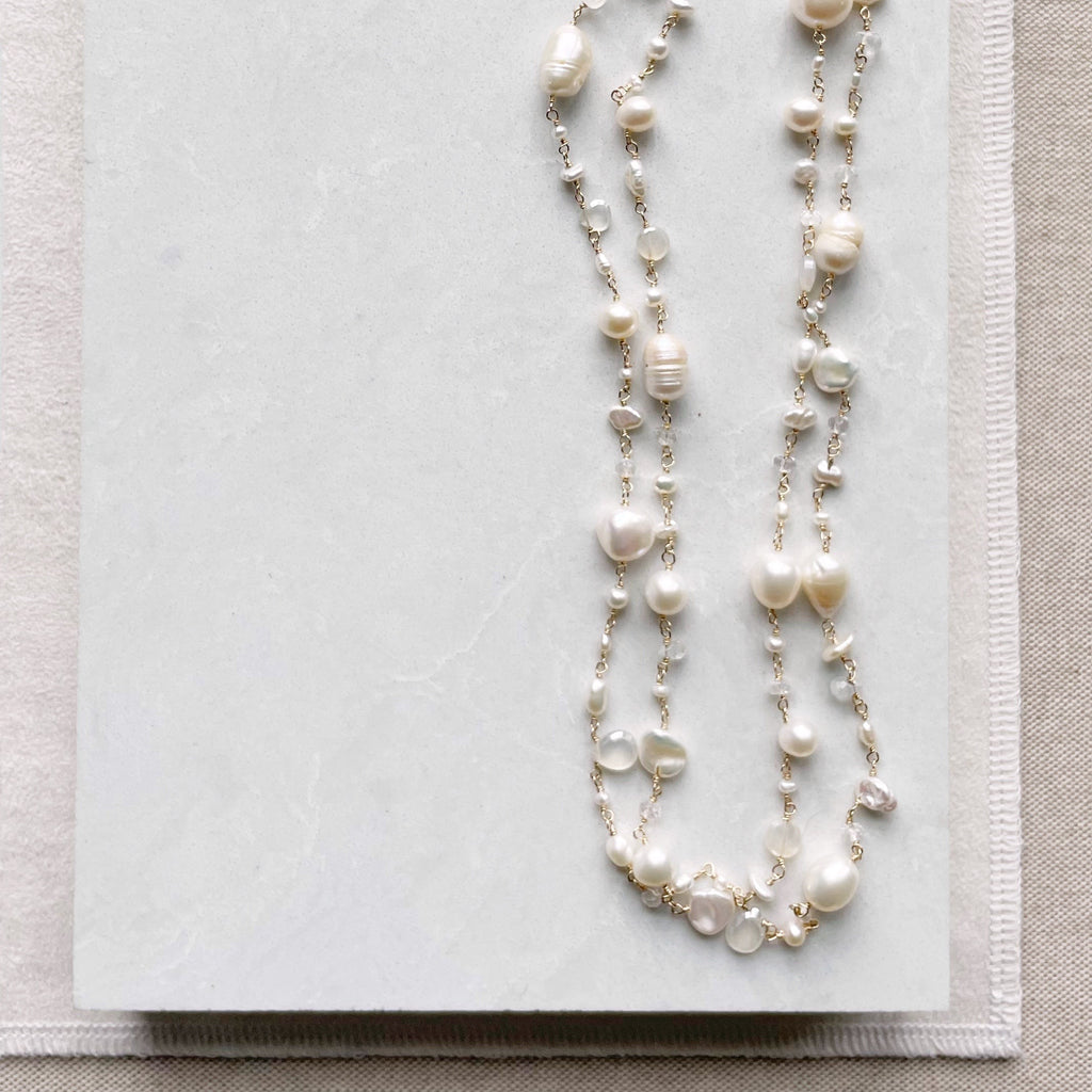 Gold, pearl and gemstone long statement pearl necklace with wire wrapped moonstone, white chalcedony, white topaz, and freshwater pearls. Poppy Linen necklace by Sarah Cornwell Jewelry