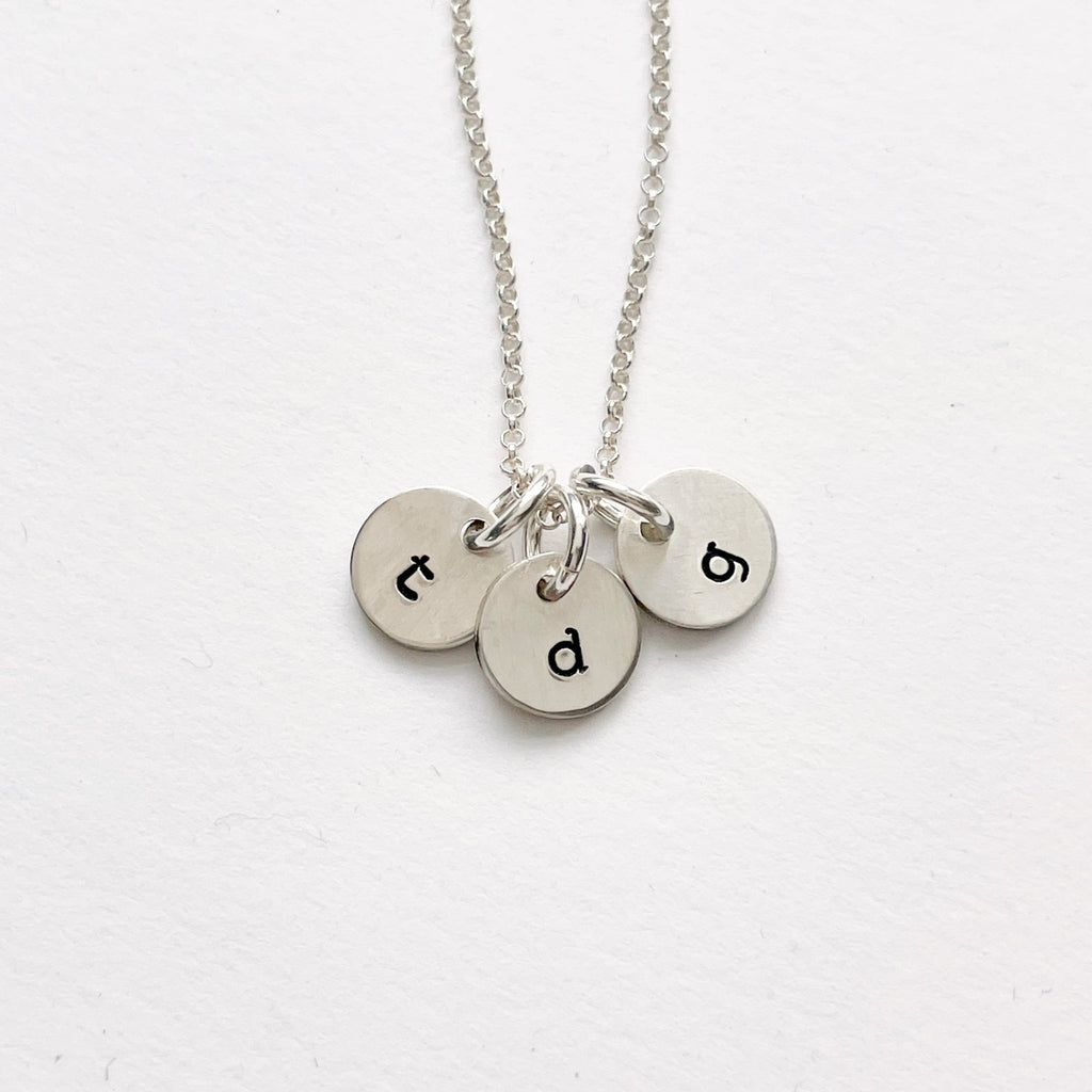Silver stamped disc personalized initial necklace with 3 silver stamped discs with initials. Tabby Necklace by Sarah Cornwell Jewelry